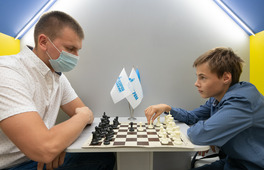 Денис Ливенец (слева) играет партию в шахматы с учеником школы